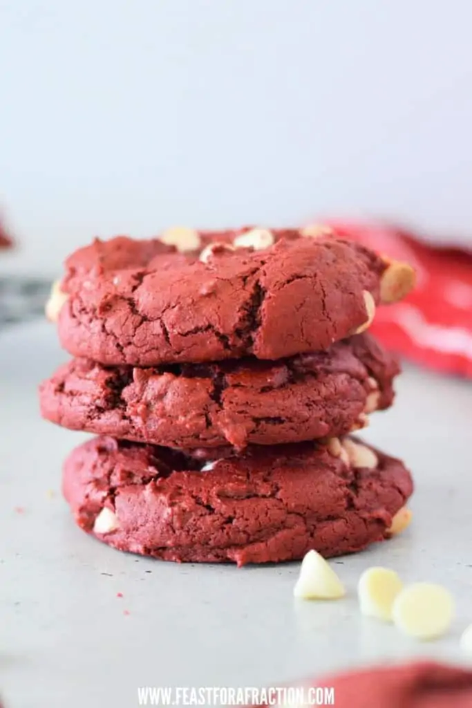 red velvet cookies with white chocolate chips stacked on counter