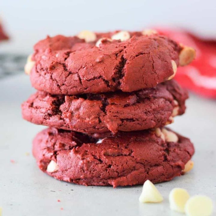 red velvet cake mix cookies with white chocolate chips stacked on counter