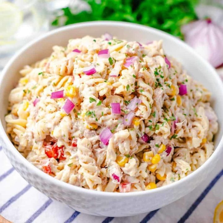 pasta salad with tuna in white bowl on blue and white napkin