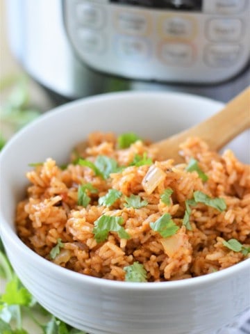instant pot mexican rice in white bowl with wooden spoon