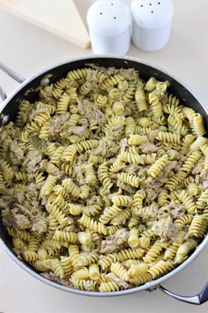 Tuna Pesto Pasta in pan with parmesan cheese, salt and pepper in background