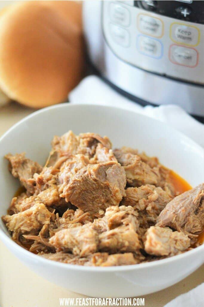 shredded pork butt in white bowl with instant pot