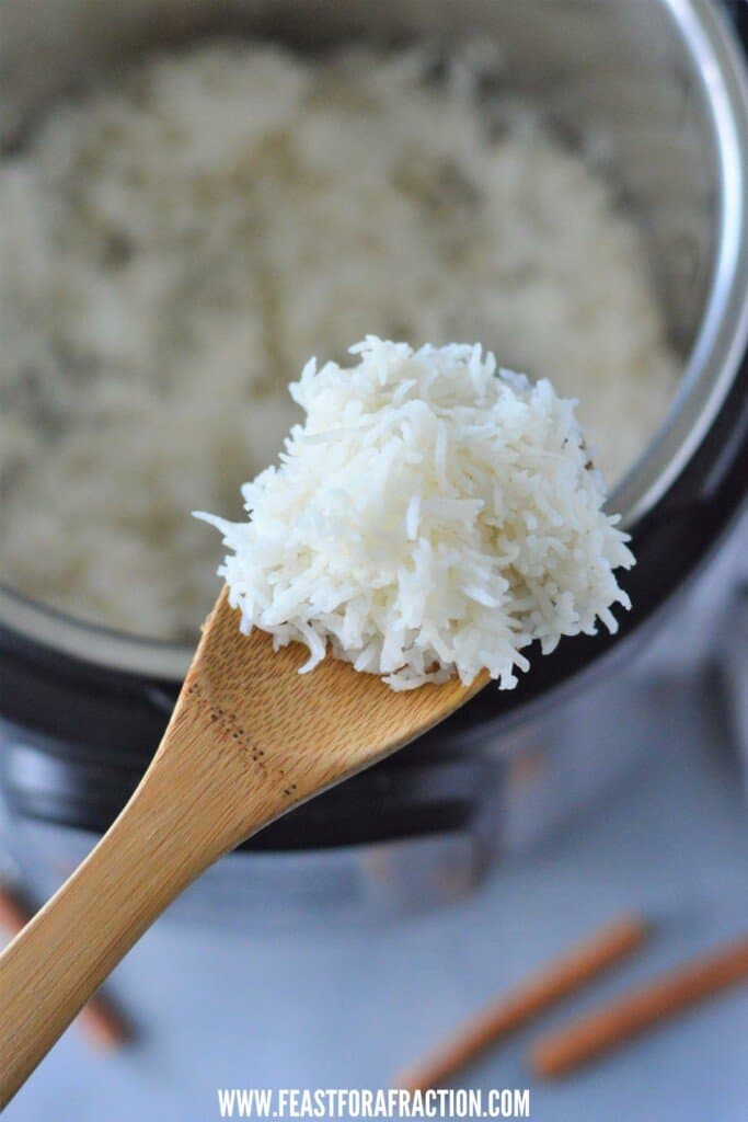 close up of a wooden spoon filled with cooked instant pot basmati rice