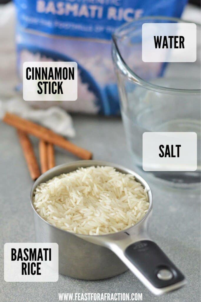 measuring cup of basmati rice, cinnamon sticks and cup of water on counter