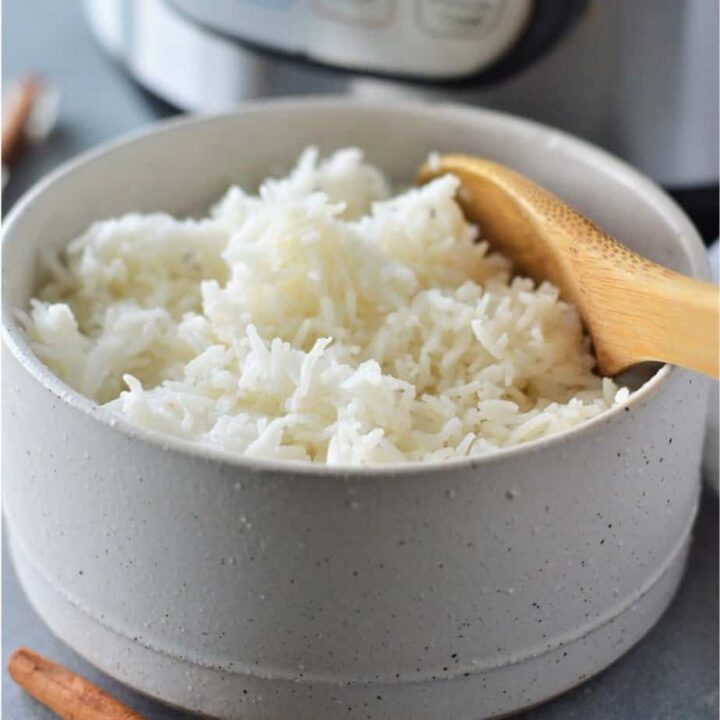 side angle view of a bowl of basmati rice with instant pot in background