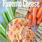 overhead view of pimento cheese in bowl on plate with crackers, carrots and celery with title text