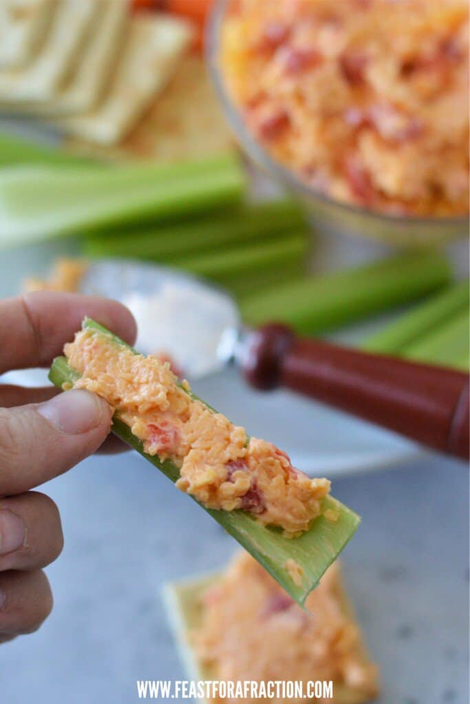 souther pimento cheese spread on celery stick with wooden spreader