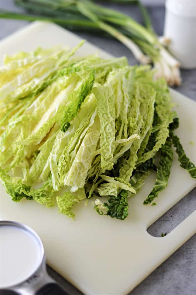 cabbage sliced on white cutting board