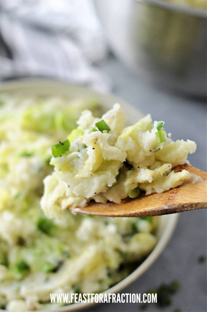 colcannon on wooden spoon with green onions