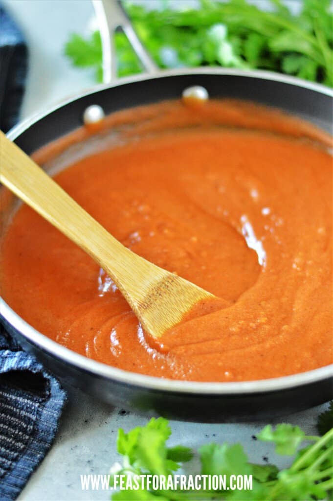 enchilada sauce in skillet with wooden spoon