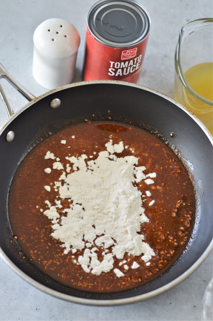 oil with taco seasoning in skillet and flour