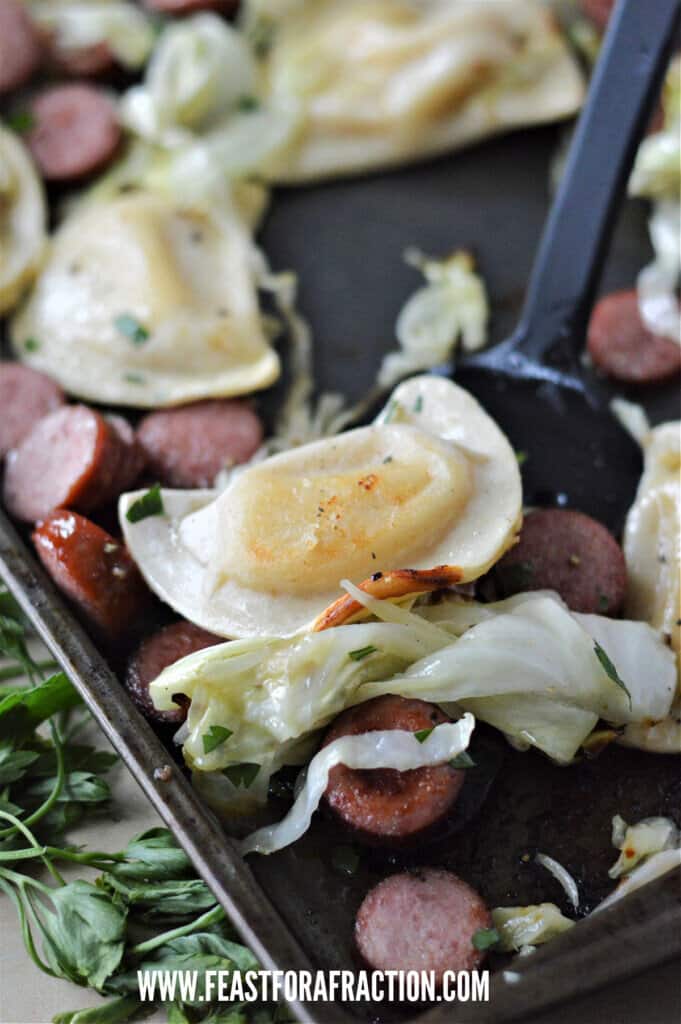 spatula serving pierogi, cabbage and sausage