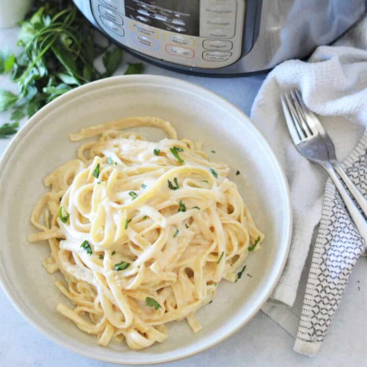 instant pot fettuccine alfredo in white bowl with parsley