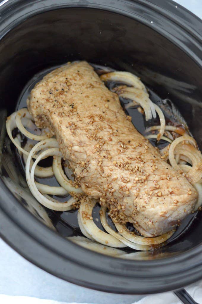 A boneless pork loin slow cooker recipe, featuring tender meat and onions cooked to perfection.