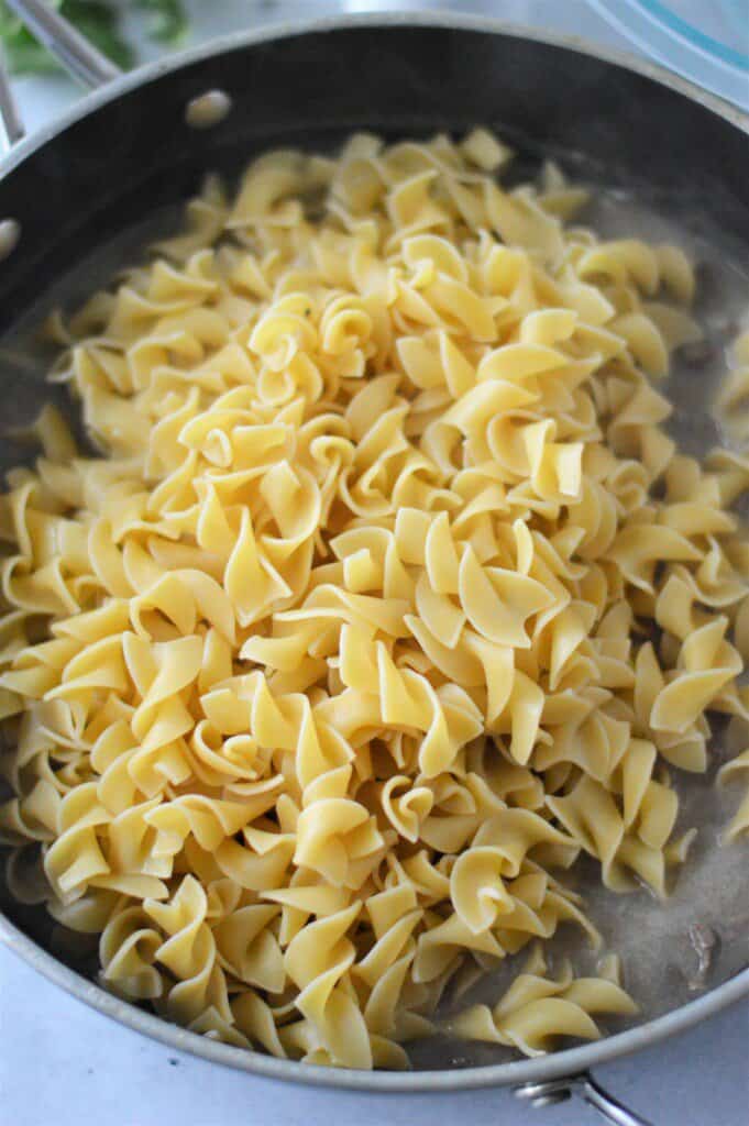 cooked egg noodles added to pan with ground beef and soup