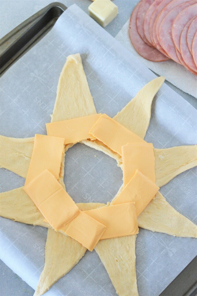 American cheese slices layered on crescents shaped in a ring on a baking pan