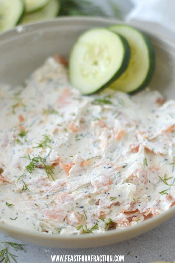 A bowl of smoked salmon dip with cucumbers.