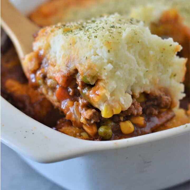 wooden spoon scooping out a serving of shepherd's pie