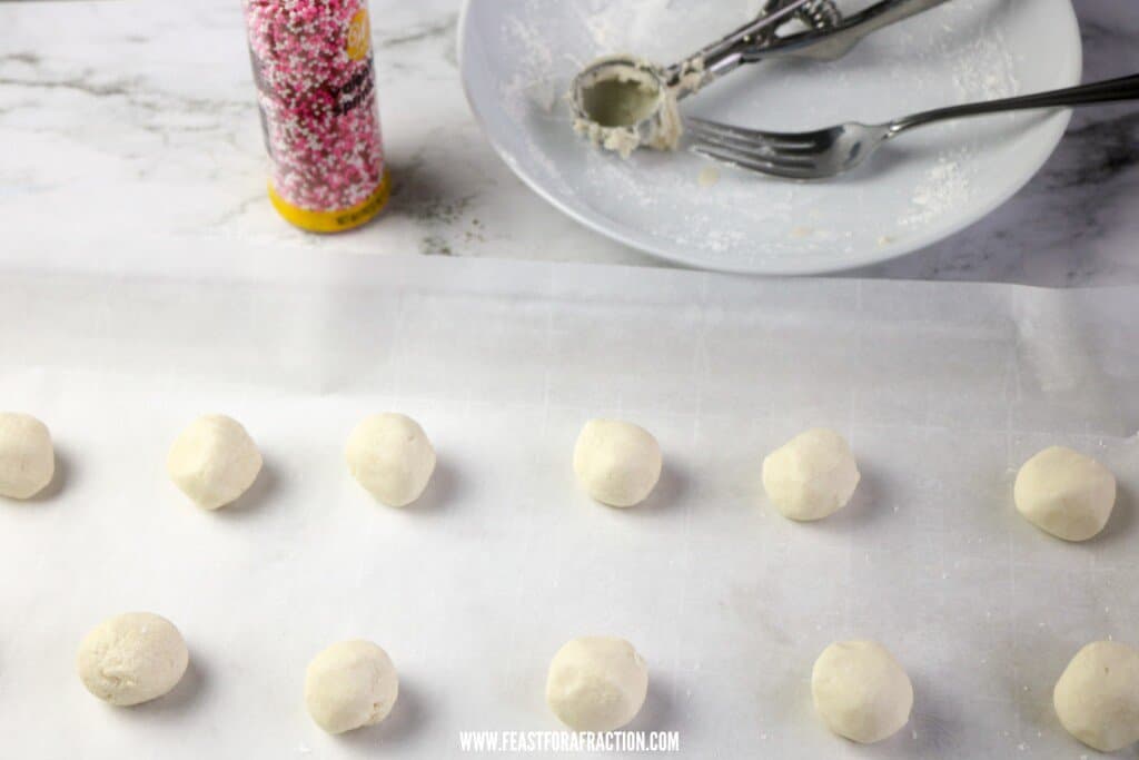 shortbread cookie dough rolled into balls on parchment lined baking pan