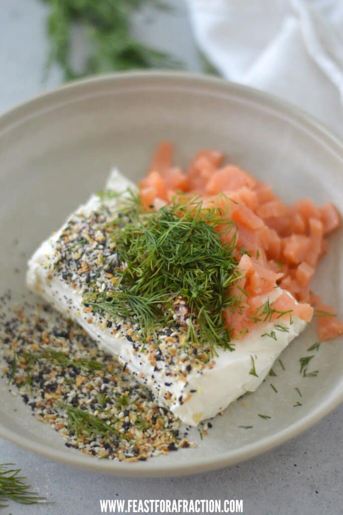 A plate with salmon, dill and sesame seeds.