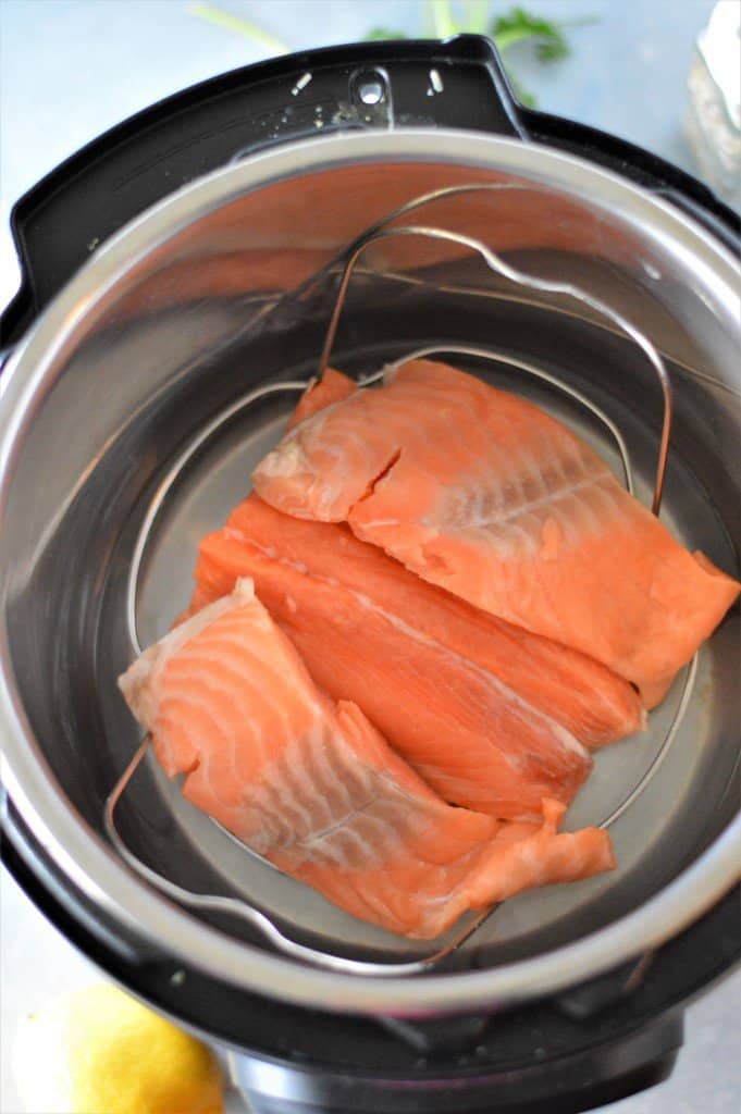 Salmon fillets sitting on trivet in instant pot pressure cooker