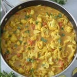 Cauliflower and chickpea curry in pan with title text