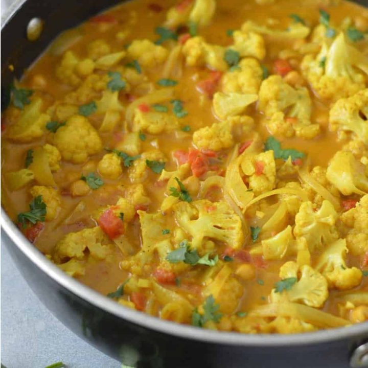 A pot of curry with cauliflower and chickpeas.