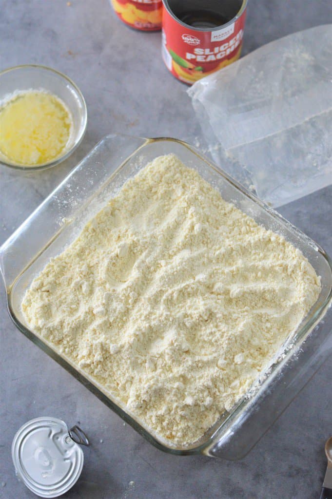 cake mix on top of canned peaches in baking dish