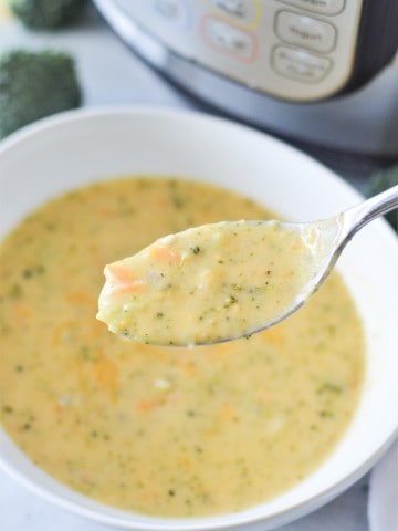 Instant pot broccoli soup in a bowl with a spoon.