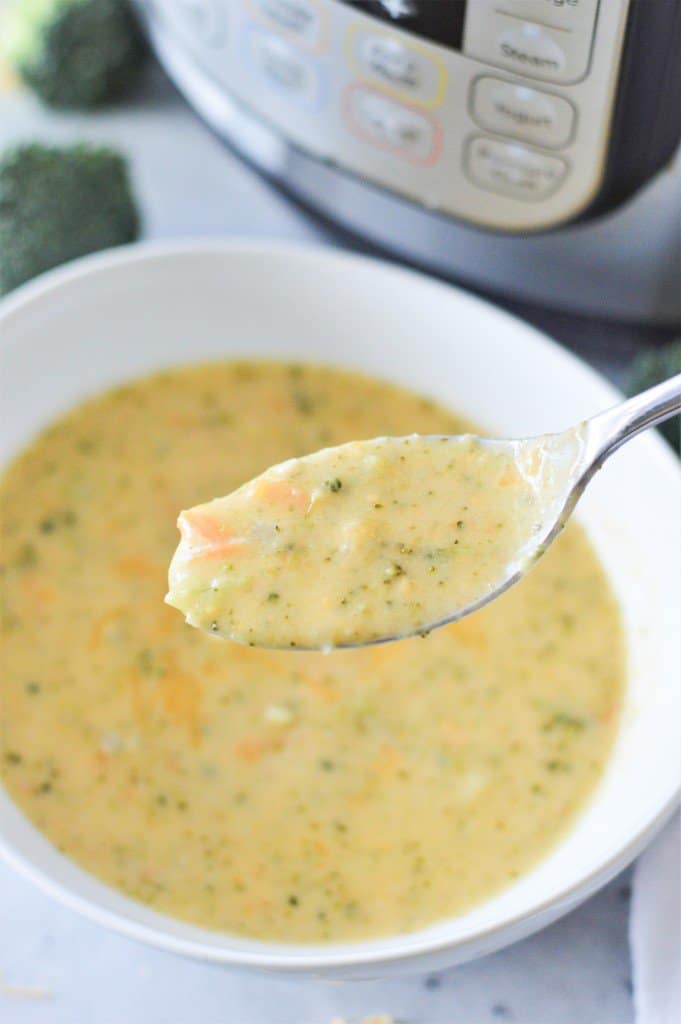 Instant pot broccoli soup in a bowl with a spoon.