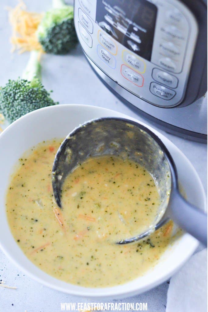 A bowl of instant pot broccoli cheese soup in front of an instant pot.