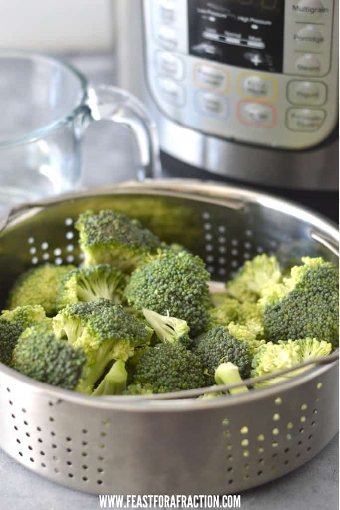 cut broccoli in steamer basket with instant pot in background