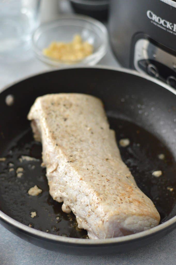 pork loin being seared in a skillet