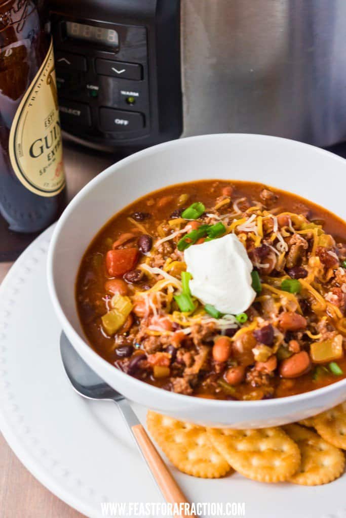 beef chili with stout beer in white bowl with spoon and crackers