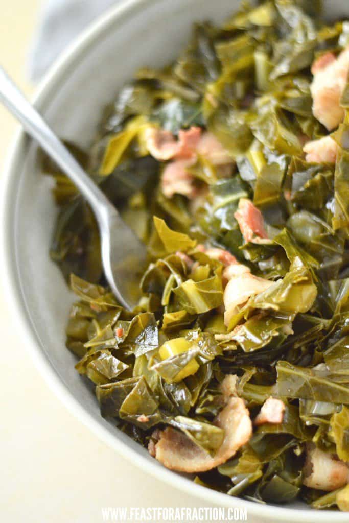 A bowl of collard greens with bacon and a fork.