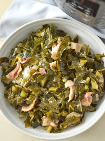 A bowl of collard greens and bacon in front of an instant pot.