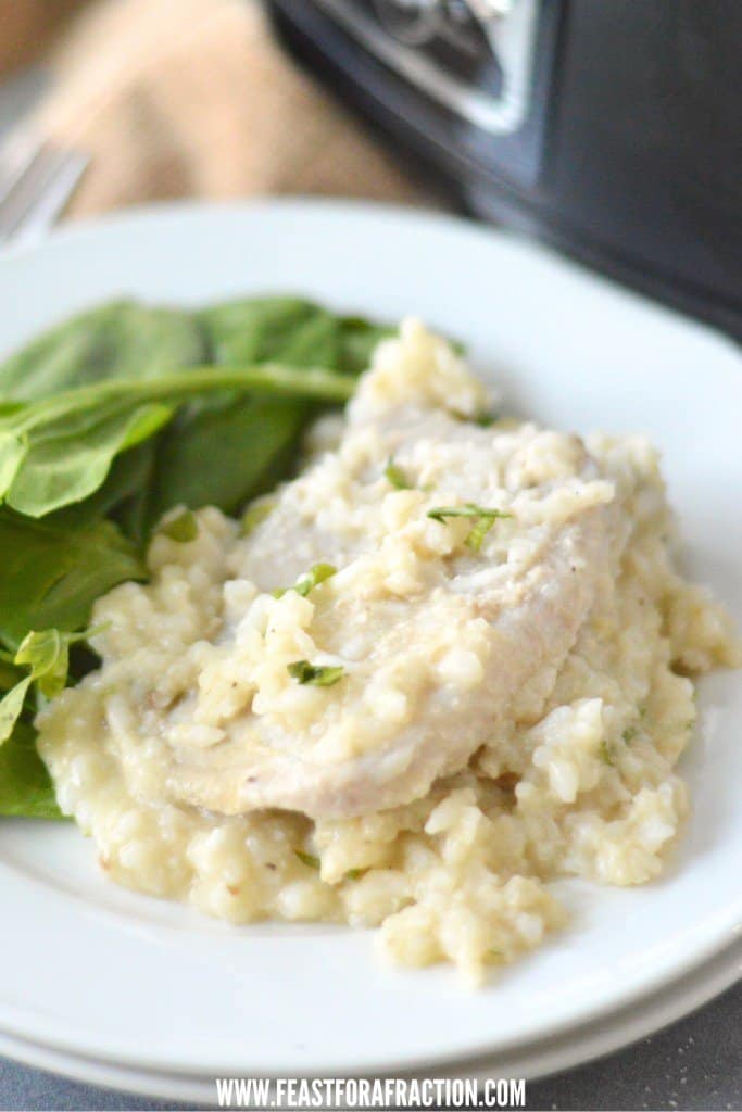 boneless pork chop and creamy rice on stacked white plates with slow cooker in background