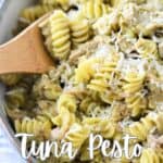a bowl of pesto pasta with tuna topped with grated parmesan cheese with title text