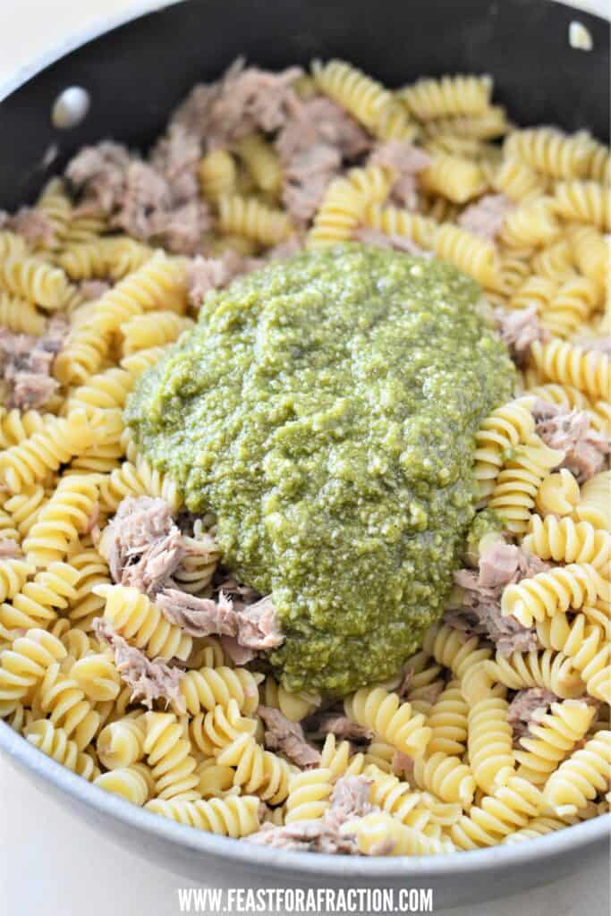 cooked pasta, canned tuna and pesto sauce in pan