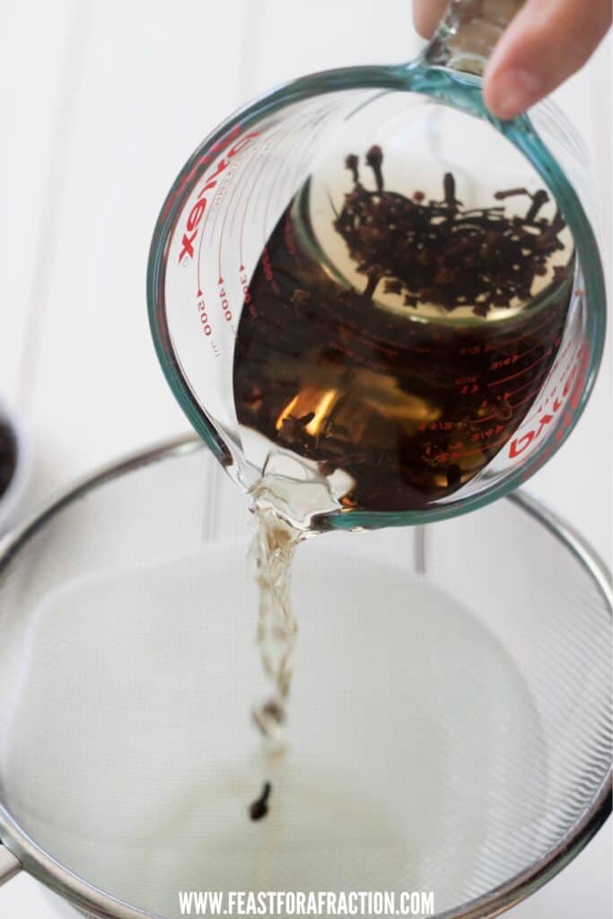 clove mouthwash being strained into a bowl