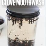 Jar of homemade clove mouthwash with cloves visible inside.