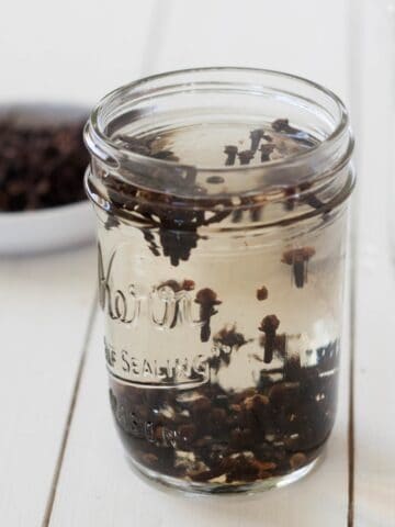 whole cloves and water in a mason jar steeping to create clove mouthwash