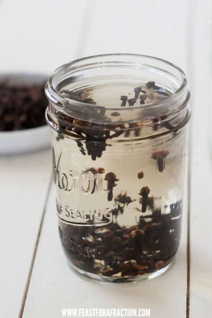 whole cloves and water in a mason jar steeping to create clove mouthwash