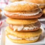 A close-up of a stack of pineapple whoopie pies, sprinkled with powdered sugar.