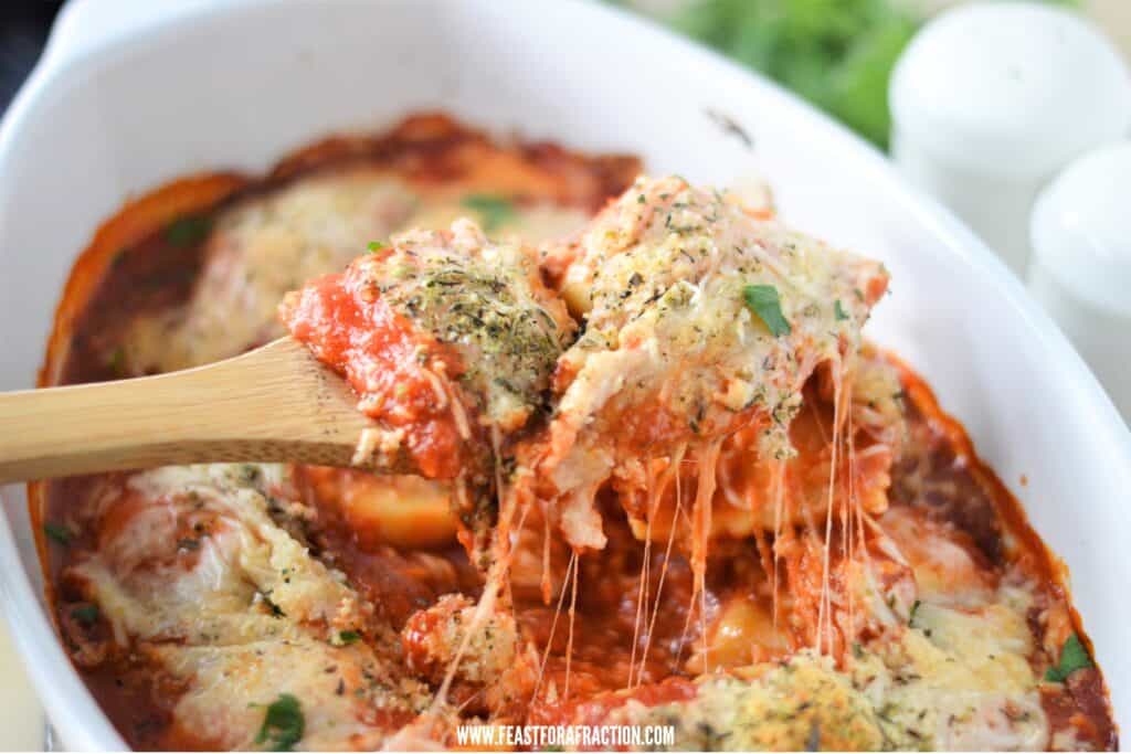 horizontal view of ravioli, pasta sauce and cheese baked in a casserole dish