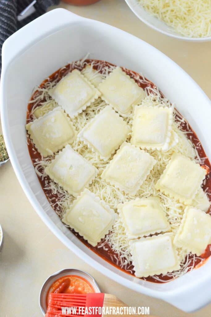 frozen ravioli layered on top of pasta sauce and cheese for lazy lasagna