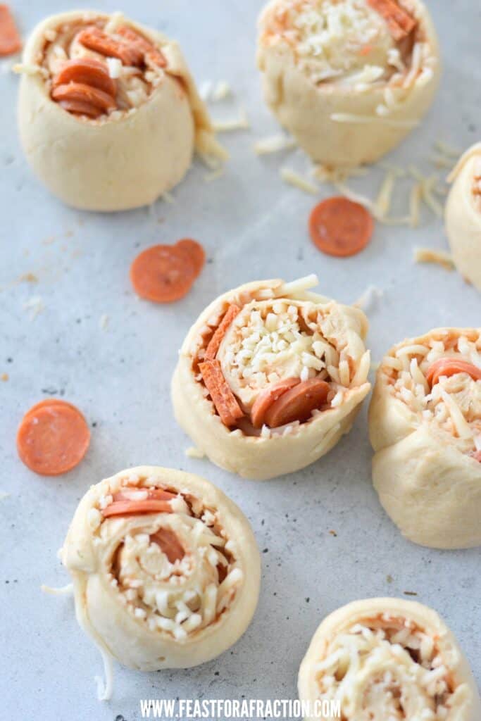 unbaked pepperoni pizza crescent pinwheels on blue counter